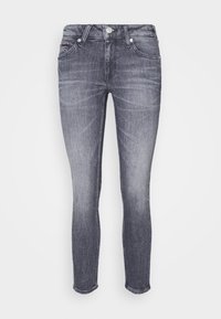 Jeans skinny de mezclilla gris con un clásico diseño de cinco bolsillos, un sutil desgastado y cierre de botón en el frente.