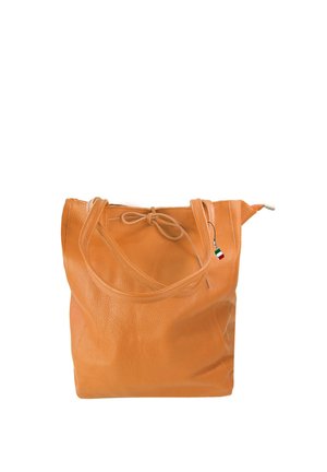 Sac cabas en cuir marron clair avec doubles poignées, un détail de nœud noué en haut et un petit pendentif drapeau italien accroché à une poignée.