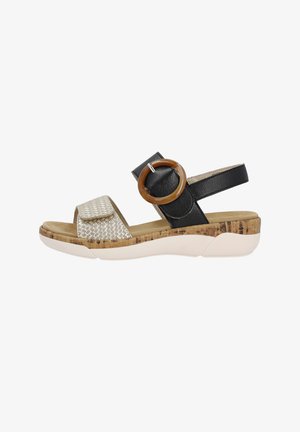 Black and silver sandal with woven strap, cork-like sole, and ankle band featuring a round accent. Light padding on the footbed.
