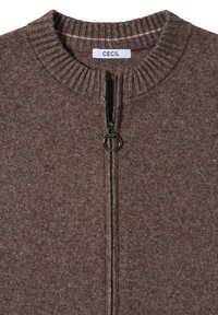 Brun zip-up tröja med en ribbad rund krage, texturerad tyg och en svart dragkedja. Etiketten säger "CECIL."