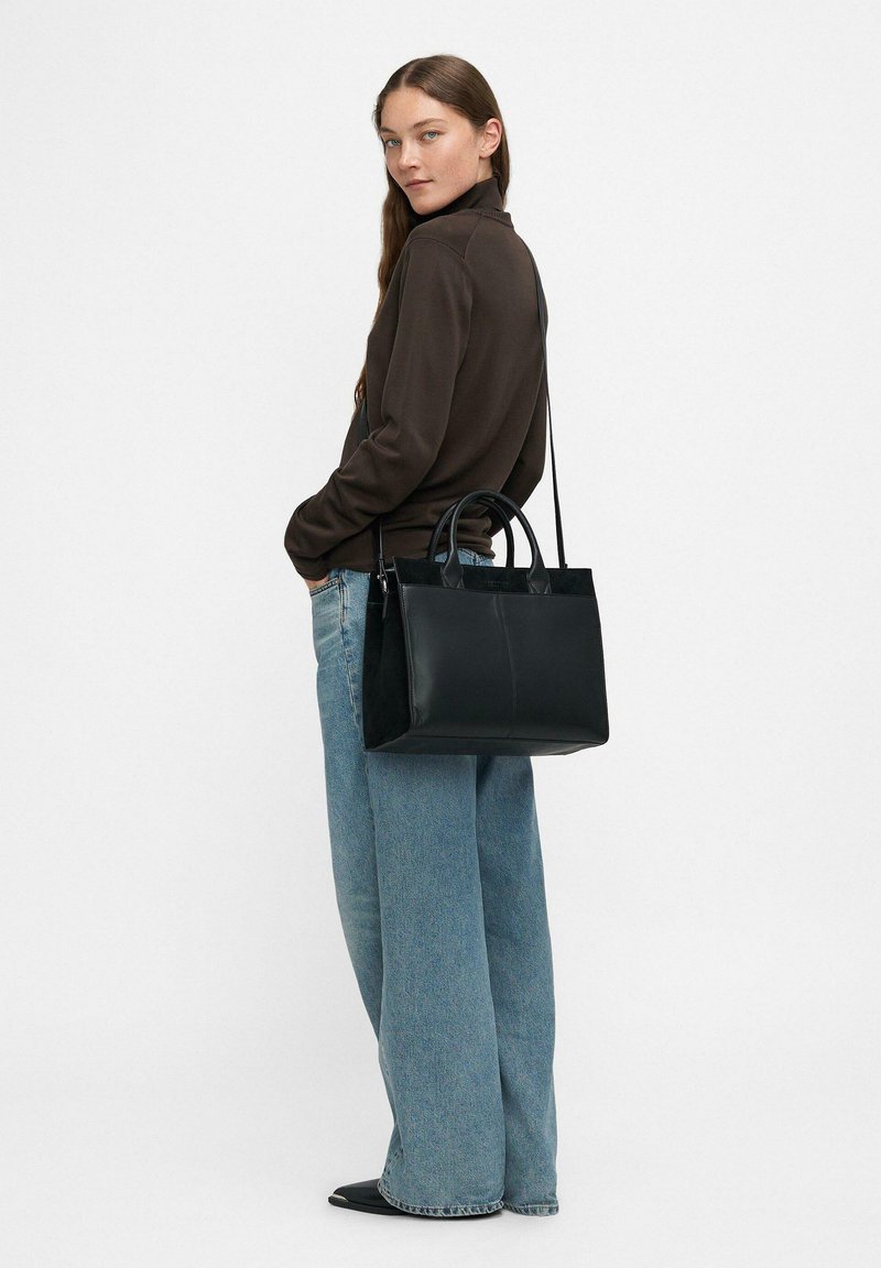 Schwarze Leder Tragetasche mit doppelten Obergriffen und einem verstellbaren Schultergurt; hat ein elegantes Design und eine glatte Textur.