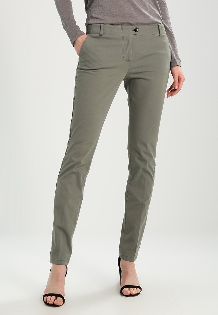 Khakifarbene, schlank geschnittene Hose mit Fronttaschen, einem Knopfverschluss und einer glatten Textur, kombiniert mit schwarzen Sandalen mit hohem Absatz.