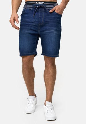 Shorts en denim bleu foncé avec une taille élastique, des détails de cordon de serrage et deux poches latérales ; présentent une coupe droite et un ourlet retroussé.