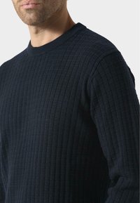 Maglione in maglia blu navy con un motivo testurizzato di piccole quadrati, dotato di scollatura rotonda e maniche lunghe.