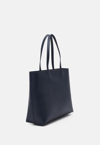 Laivastonsininen nahkainen olkalaukku, jossa on kaksi pitkää kahvaa, tyylikäs suorakulmainen muoto, sileä pinta ja minimalistinen muotoilu.