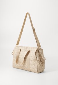 Beige quiltet veske med mønstret tekstur og doble topphåndtak. Justerbar skulderreim og innsamlet side detalj. Har en elegant design.