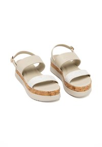 Due sandali platform con una parte superiore bianca texturizzata e una suola intermedia in stile sughero, dotati di una fascia regolabile e una suola leggera e liscia.
