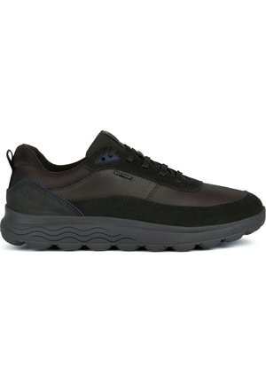 Sneaker nera con una combinazione di pelle liscia, dettagli in suede e una suola in gomma testurizzata con bordi arrotondati. Design con lacci e accenti sottili.