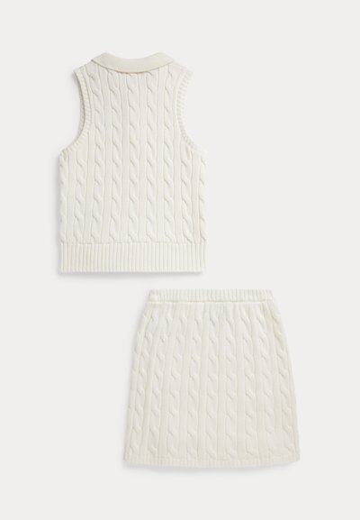 White cable-knit sweater vest with ribbed collar and hem, paired with a matching ribbed skirt featuring a similar cable-knit pattern.