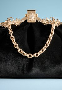 Geantă din satin negru cu un maner din lănțișor auriu, accente florale din cristale și un închizător auriu cu un design floral.