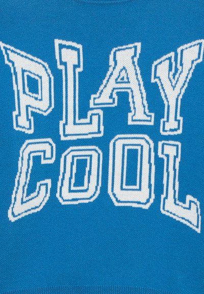 Λευκά γράμματα με περίγραμμα που σχηματίζουν τη φράση «PLAY COOL» σε φωτεινό μπλε πλεκτό ύφασμα.