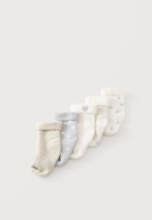 Cinq paires de chaussettes pour bébé pliées dans des couleurs neutres avec des motifs de cœur et de rayures sur un fond clair.