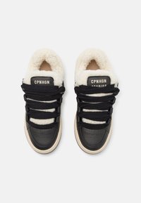 Svarte lær sneakers med kremfarget faux shearling-foring, tykke svarte snorer og en beige gummisåle; har logomerker på tungen.