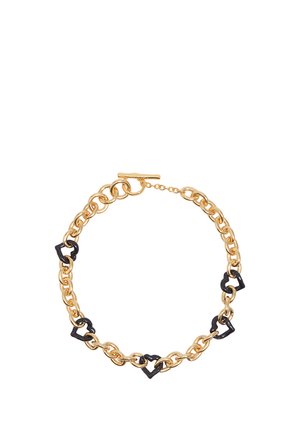 Collar de cadena dorada con eslabones intercalados en forma de corazón negro y cierre de palanca sobre un fondo blanco.