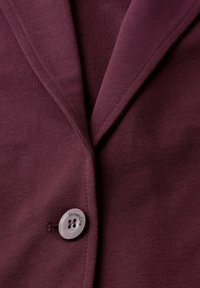 Blazer in tessuto bordeaux con colletto a revers e un bottone rotondo e trasparente con incisione "StreetOne". Materiale liscio e texture.