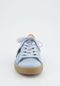  Lichtblauwe sneaker met witte veters, rubberen zool en oranje accent op de tong. Heeft textuurleer zijkanten en zwarte details.