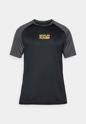 Schwarzes sportliches T-Shirt mit kurzen Raglanärmeln, das ein strukturiertes Muster aufweist und ein gelbes "BERLIN RUN"-Logo mit einem roten Akzent hat.