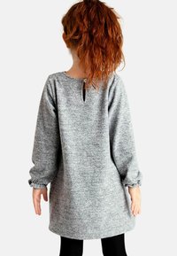 Siva pletena obleka z dolgimi rokavi, okroglim izrezom in majhnim odprtjem na hrbtu. Mehka tekstura, sproščen kroj in naborki na manšetah.