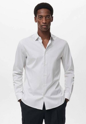Long-sleeve white shirt with vertical navy stripes, button-down collar, and fitted design. Smooth fabric with a subtle sheen.