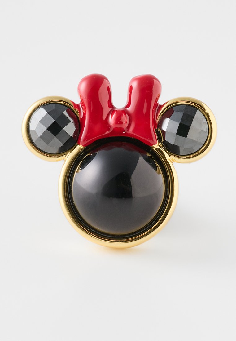 Mickey-Maus-Themenbrosche mit einem schwarzen, kugelförmigen Zentrum, rotem Schleifenakzent und zwei schwarzen, edelsteinähnlichen Elementen, eingefasst in goldfarbenem Metall.