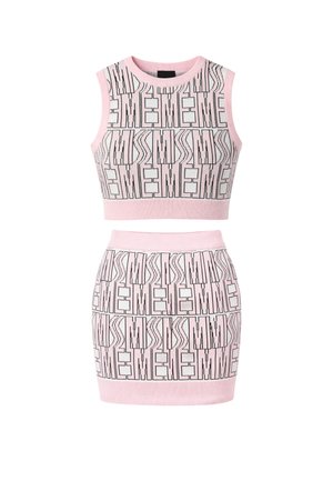 Top corto senza maniche in maglia rosa e minigonna abbinata con motivo geometrico astratto nero e bianco ripetuto.