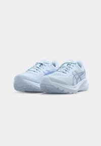 Scarpe sportive azzurro chiaro con tomaia in rete, suola testurizzata e dettagli blu scuro. Presentano lacci e un design traspirante.