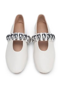 Bailarinas de piel blanca con punta abierta y un detalle de cadena plateada en la parte frontal, con una textura suave y un diseño redondeado.