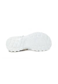 Suela de goma blanca con un patrón de textura, que presenta surcos e indentaciones circulares para mejorar el agarre y la tracción.
