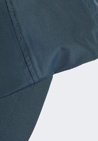 Cappello blu scuro realizzato in tessuto liscio e resistente all'acqua. Presenta una visiera leggermente curvata e cuciture a vista, con un design minimalista.