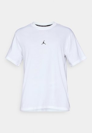 Camiseta de algodón blanca con cuello redondo, mangas cortas y un pequeño logo de Jumpman negro en el pecho. Textura suave y diseño de corte estándar.