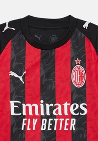 Maillot de l'AC Milan avec des rayures verticales noires et rouges, tissu texturé, col noir, logo blanc avec étoile rouge et texte du sponsor.