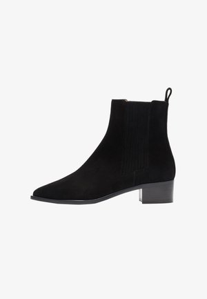 Anfibio in suede nero con punta appuntita, pannelli laterali elasticizzati e tacco a blocco di piccole dimensioni. L'anfibio presenta cuciture decorative sui lati.