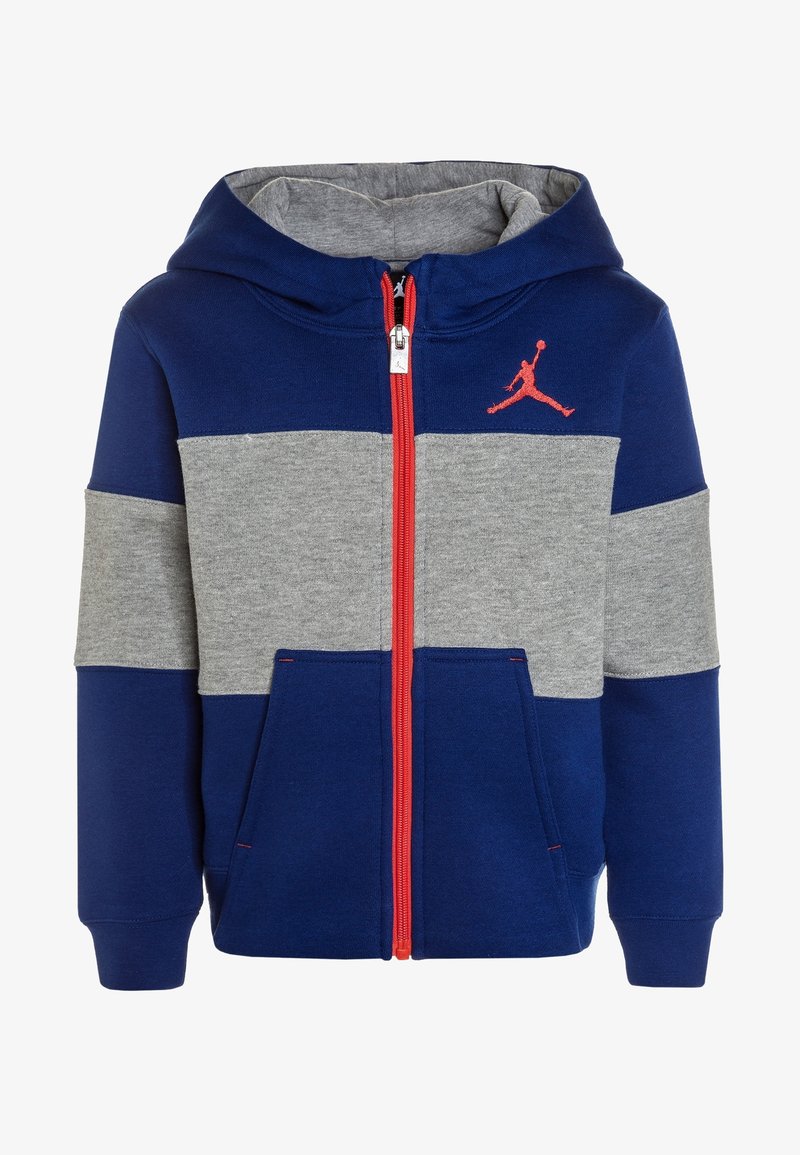 Sweat à capuche zippé pour enfants avec blocs de couleurs bleu et gris, fermeture éclair rouge, poches frontales, capuche et logo Jordan rouge sur la poitrine.
