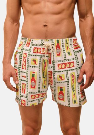 Men's swim shorts with a colorful pattern of Tabasco bottles, chili peppers, and lemon wedges on a white background.