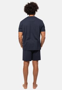 Mørkeblå atletisk sæt bestående af en kortærmet, stribet T-shirt og matchende shorts. Blødt stof med en afslappet pasform, designet til komfort.