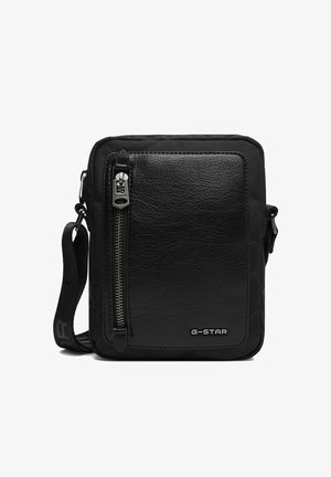 Bolso de hombro negro de G-Star con bolsillo frontal texturizado, cremallera vertical y correa ajustable con marca, sobre fondo blanco.