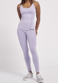 Canotta sportiva viola con dettagli in rete e logo, abbinata a leggings viola coordinati con strisce laterali, tessuto testurizzato e design aderente.