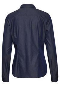 Camisa de botones azul marino con mangas largas, un cuello clásico y un dobladillo curvado. Hecha de una tela suave con un ligero lustre.