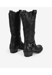 Botas de cuero negras hasta la rodilla con punta redondeada, cremallera lateral y tira decorativa con tachuelas plateadas. Acabado mate texturizado.