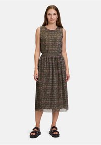 Mouwloze jurk met patroon in donkergroen met roze accenten, met een geplooid ontwerp en een getailleerde taille, gecombineerd met zwarte sandalen.