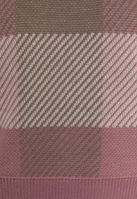 Tissu tricoté avec un motif à carreaux dans des nuances de rose, marron et crème ; présente des rayures diagonales et une surface texturée.