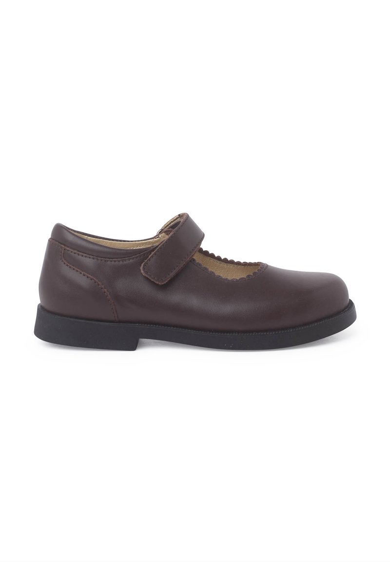 Zapato Mary Jane de cuero marrón con puntera redondeada, bordes festoneados y correa ajustable. La suela de goma ofrece tracción y comodidad.