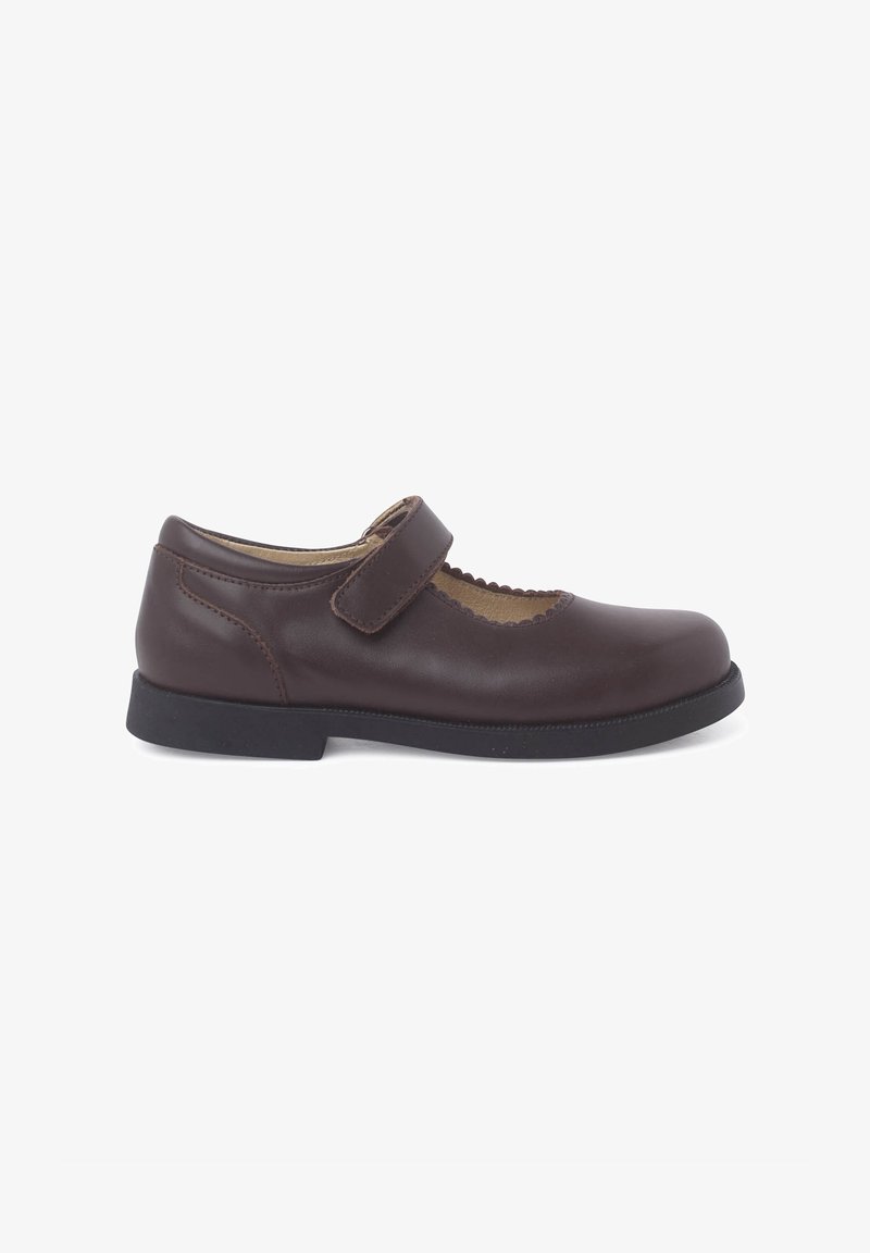 Chaussure Mary Jane en cuir marron avec un bout rond, des bords festonnés et une sangle réglable. La semelle en caoutchouc offre traction et confort.