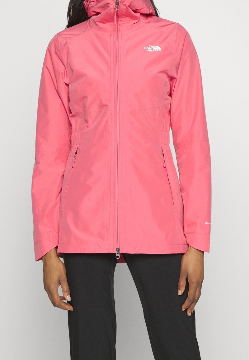Chaqueta impermeable rosa con diseño ajustado, cuello alto y cremallera frontal. Cuenta con dos bolsillos laterales y detalle del logo en el pecho.