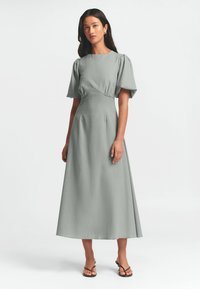 Graues Midi-Kleid mit kurzen Puffärmeln, taillierter Passform und A-Line-Silhouette; glatter Stoff mit minimaler Struktur.
