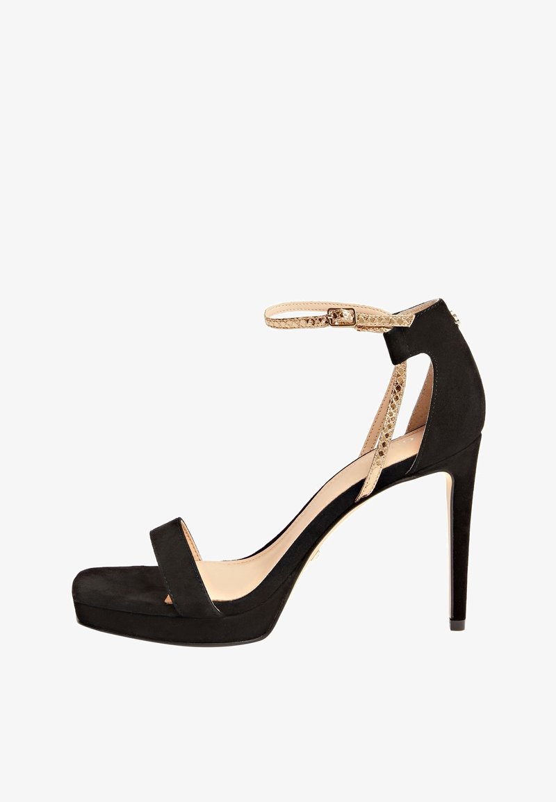 Chaussure à talons hauts en suede noir avec une plateforme, comportant une bande avant étroite, une sangle de cheville avec une texture serpent, et un bout pointu.