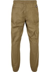 Pantalones caqui con cintura elástica, con una textura suave, dos bolsillos traseros y una pequeña etiqueta de marca en el lado derecho.