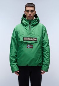 Vihreä nylonsweater, jossa on etutasku, musta logo ja Norjan lippu. Hupparimalli, jossa on vetoketjusuljenta ja elastiset hihansuut.