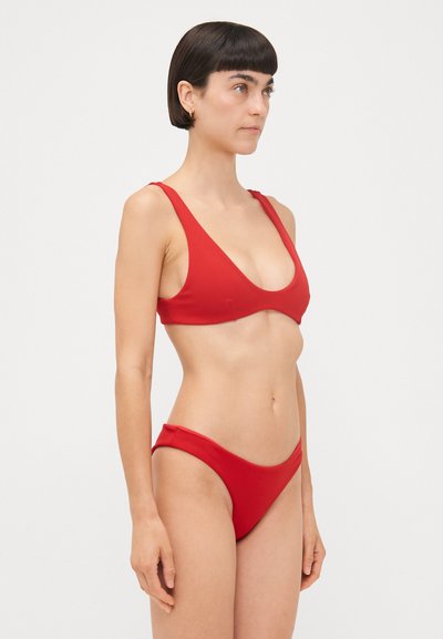 Ensemble bikini rouge comprenant un haut à col rond avec de larges bretelles et un bas à taille basse, fabriqué à partir d'un tissu lisse et extensible.
