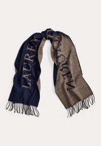 Jūras spēku un brūna pārbaude ar frizētām malām; vienā pusē ir izteikta apdruka un maiga tekstūra, izgatavota no siltas auduma.